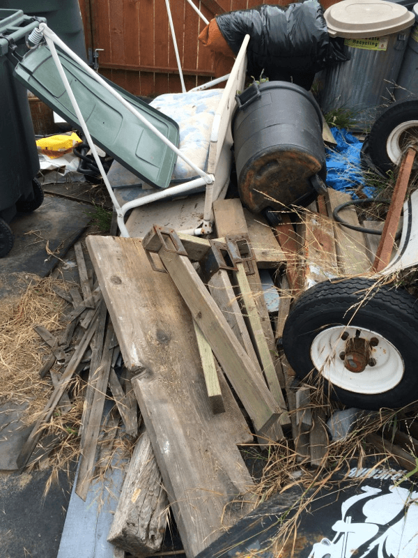 Old lumber, barrels, and mixed demolition debris ready for light demolition cleanup