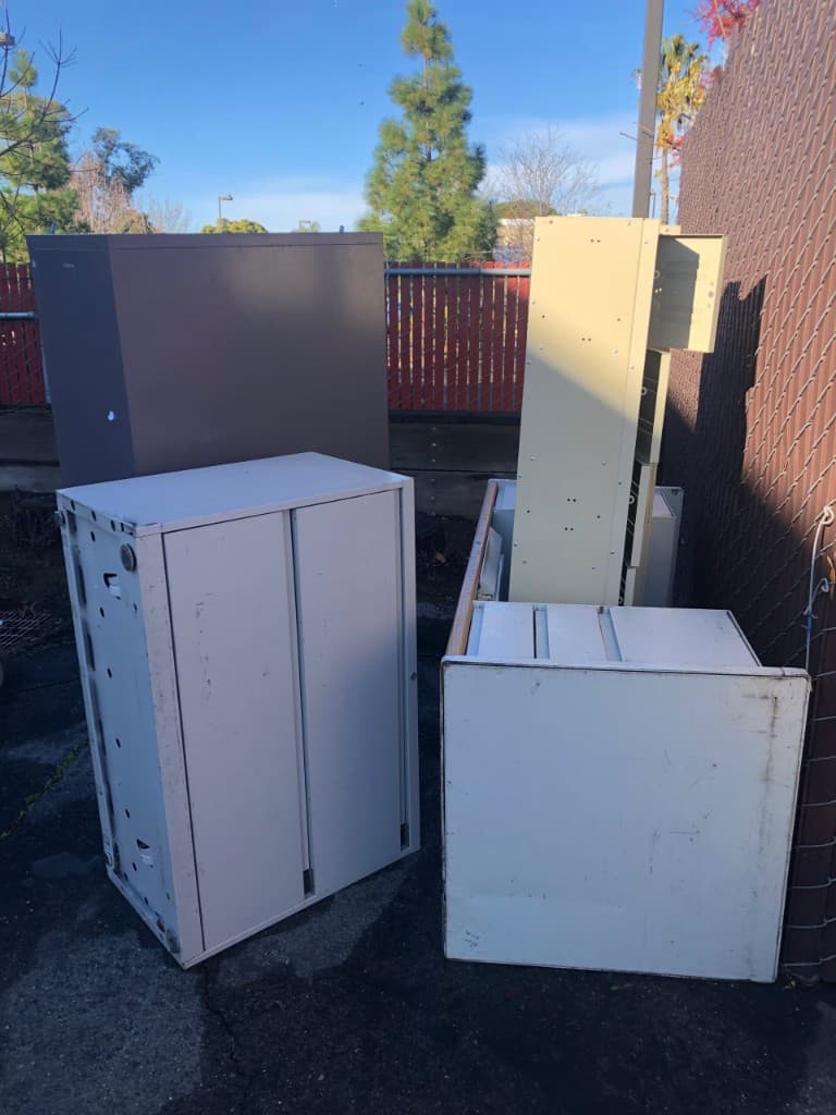 Filing cabinets and office furniture staged outside for removal by JC Junk Hauling