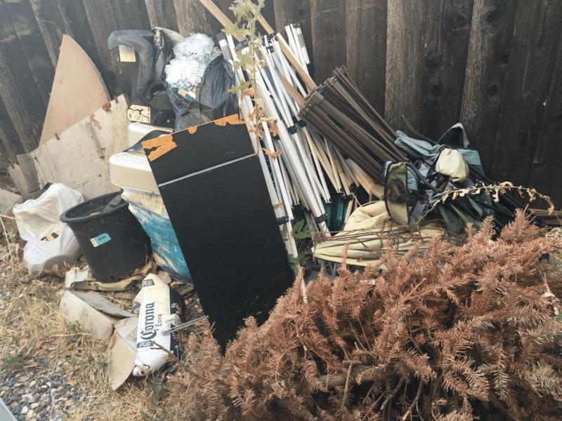 Furniture and mixed household items piled outside for removal by JC Junk Hauling
